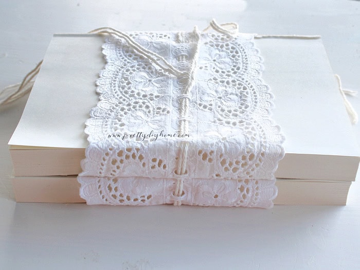 Vintage lace wrapped around a book stack with twine securing the ribbon between the pages
