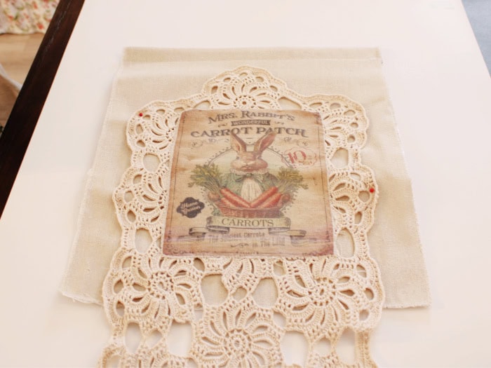 Crochet panel with bunny appliqué sewn onto the linen front panel for the DIY bunny wall pocket.