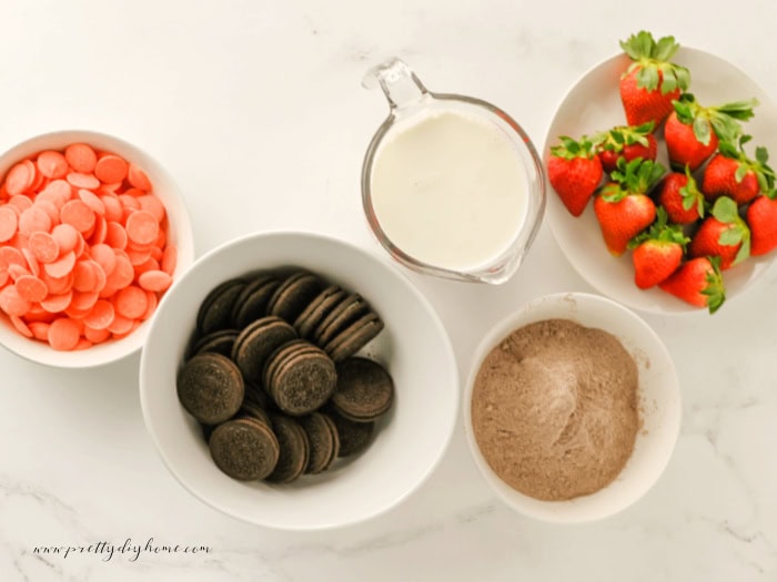 Ingredients for Easter dirt cups including pudding mix, Oreos, milk, strawberries, and orange candy melts