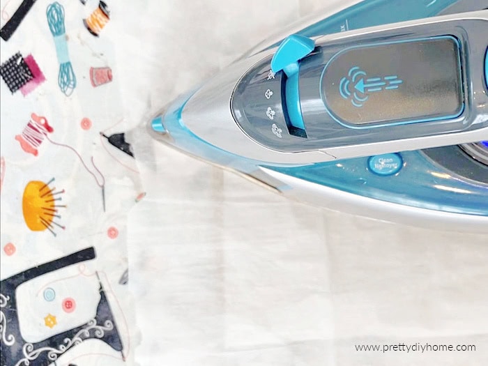 Ironing fusible interfacing onto linen using parchment paper to protect the iron.