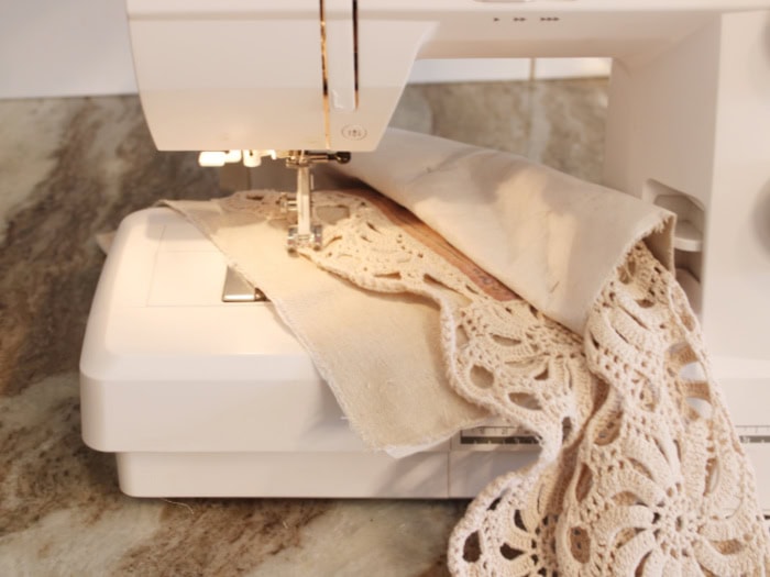 Sewing the crochet panel onto the linen front panel for the DIY bunny wall pocket.