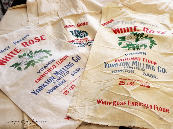 stack of vintage flour sacks from auction lot laid out on table