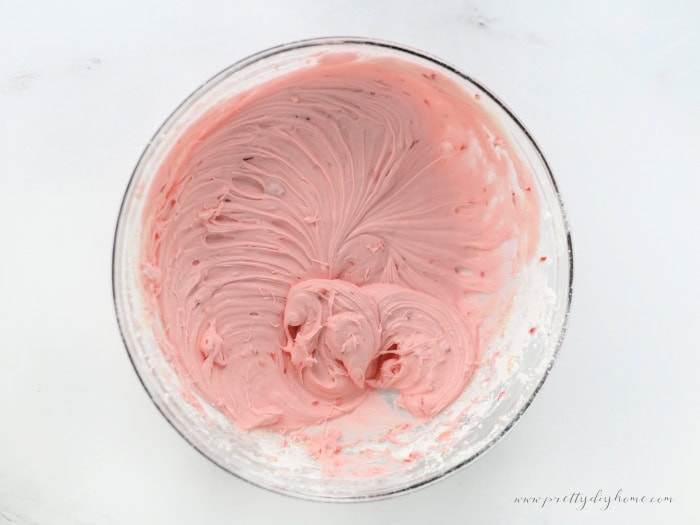 Smooth strawberry cream cheese frosting in a mixing bowl.