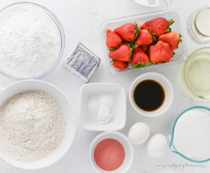 Ingredients for strawberry slab cake including fresh strawberries, flour, sugar, eggs, vanilla, and strawberry jello mix.
