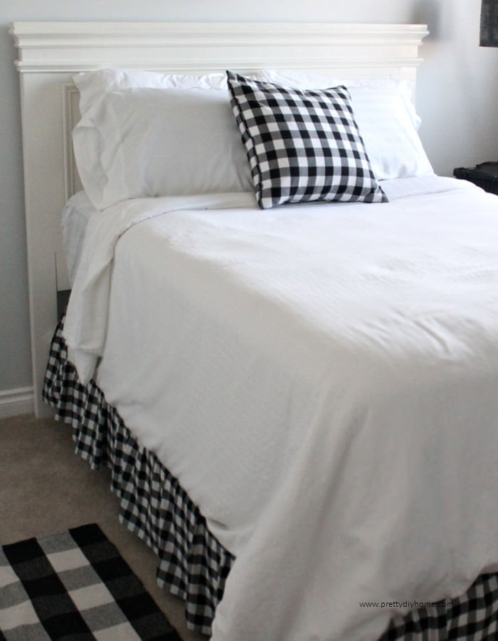 DIY Farmhouse handmade wooden farmhouse bed in a white painted finish with buffalo check bedding.