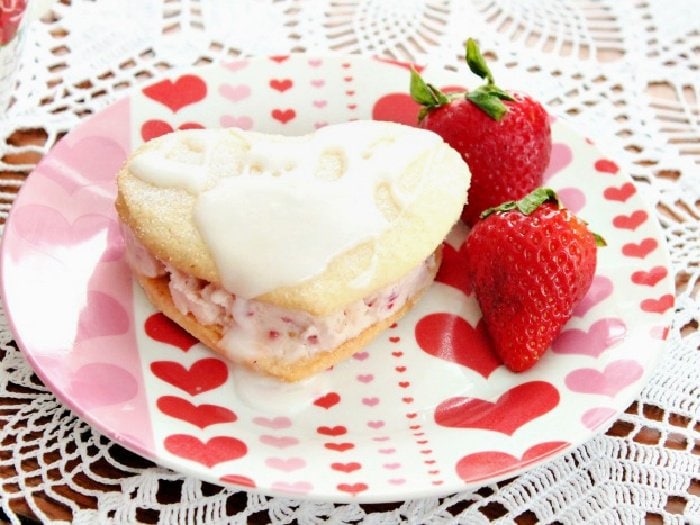 A homemade strawberry Valentines dessert recipe. Two Valentine shaped sugar cookies filled with strawberry icecream and drizzled with lemon glaze.