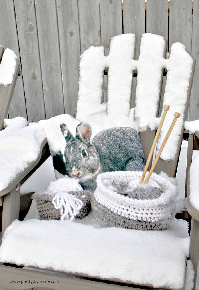 Two small wool baskets sitting on an outside chair for pretty winter decor.  The baskets are made using a free pattern.