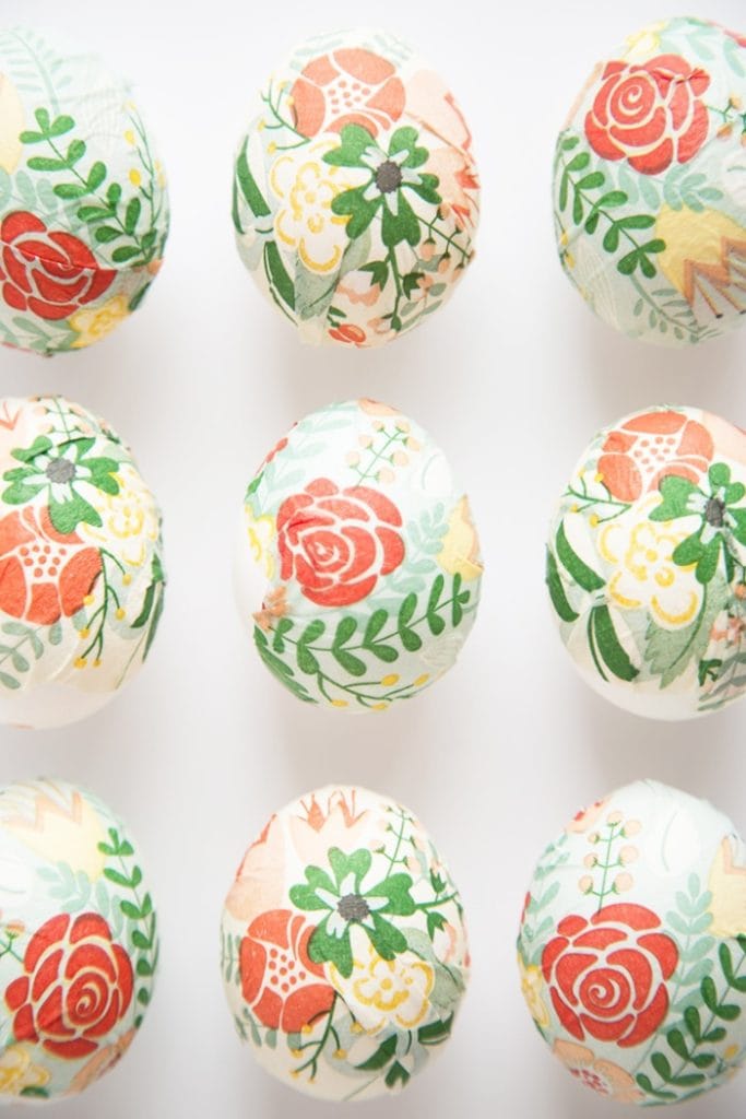 Easter eggs decorated with floral napklins in oranges greens and peach coloured.