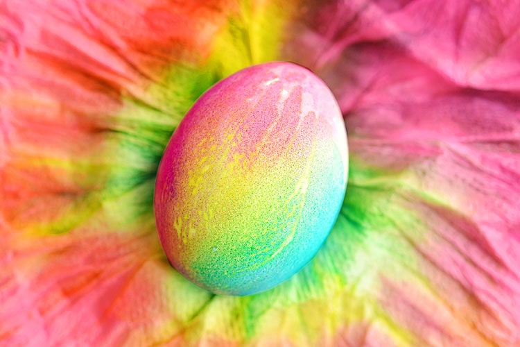 A beautiful brightly coloured Easter egg with the died paper towel in the background.