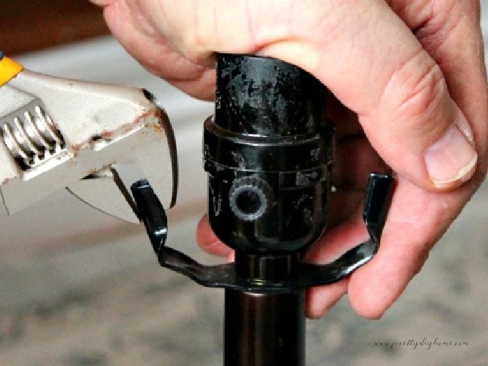 Adjusting the placement of the brackets on a lamp in order to fit on a new DIY lampshade.