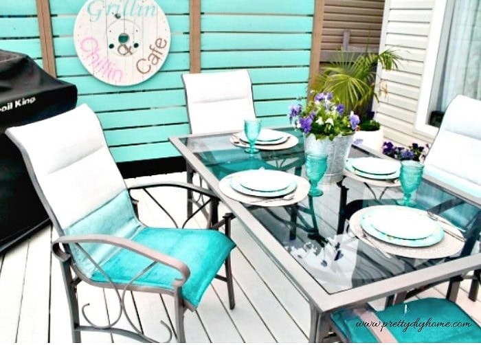 This painted metal patio set features chalk painted fabric chairs styled for outdoor dining.