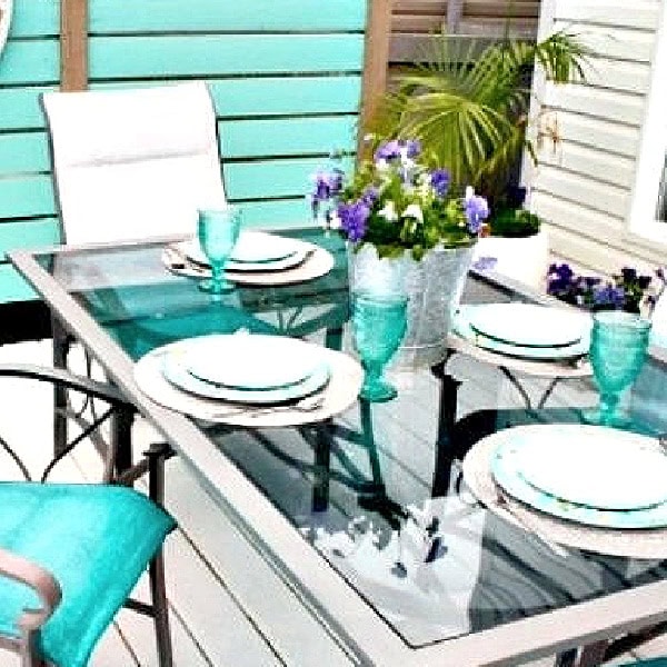 This outdoor table place setting shows the painted patio chairs styled for everyday use.