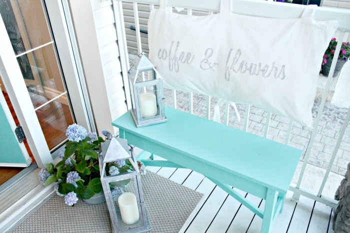 The front porch of a small yard garden tour, with DIY turquoise bench and flowers.