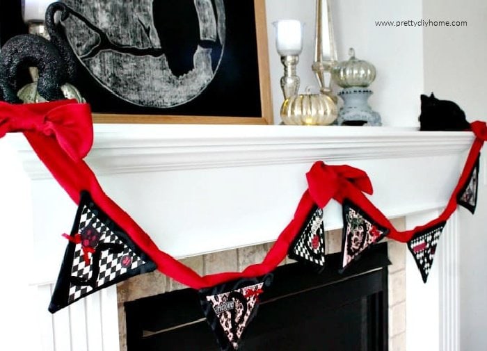 A red velvet and black handmade Halloween banner that spells out spooky.