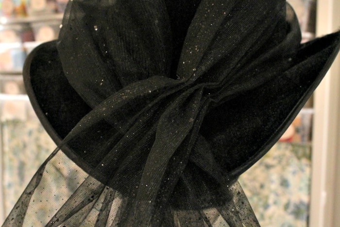 Adding embellishment to a not scary witches hat for Halloween Decor. DIY Halloween decorating idea.