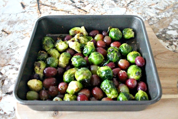 Grapes and Brussel sprouts in a pan before roasting