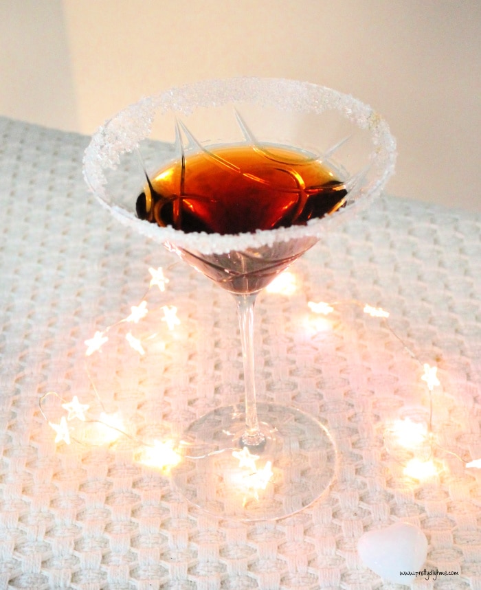 A martini glass filled with tia maria martini recipe. There are mini lights in the background.