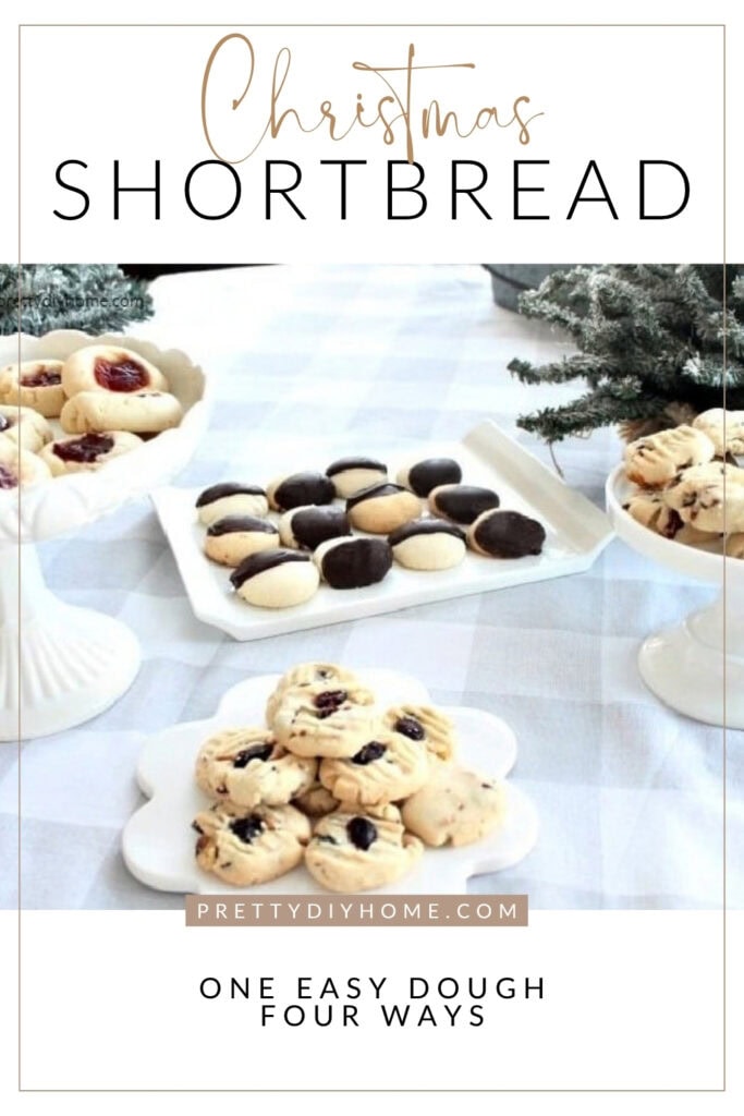 Four varieties of Christmas shortbread cookies arranged on white serving dishes beside snowy evergreen branches.