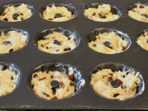 A tray of individual sized gugelhupf cakes rising in the pan.