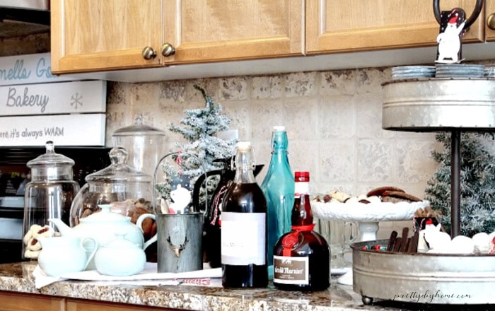 Christmas coffee bar for guests with coffee, hot chocolate, mugs, treats, and festive toppings.