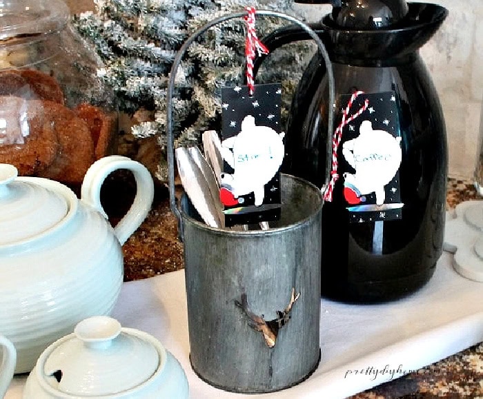 Christmas coffee station with carafe, teapot, mugs, spoons, and handmade bear tags.
