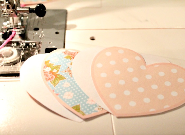 Cutting out and layering the paper Valentine banner pieces for an easy and cheap Valentine craft. A diy valentine banner free printables cut out for sewing.