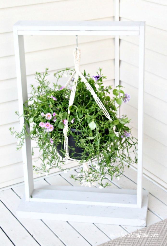 DIY wooden hanging basket for the front step, showing a simple outdoor planter displayed on a wooden hanger.