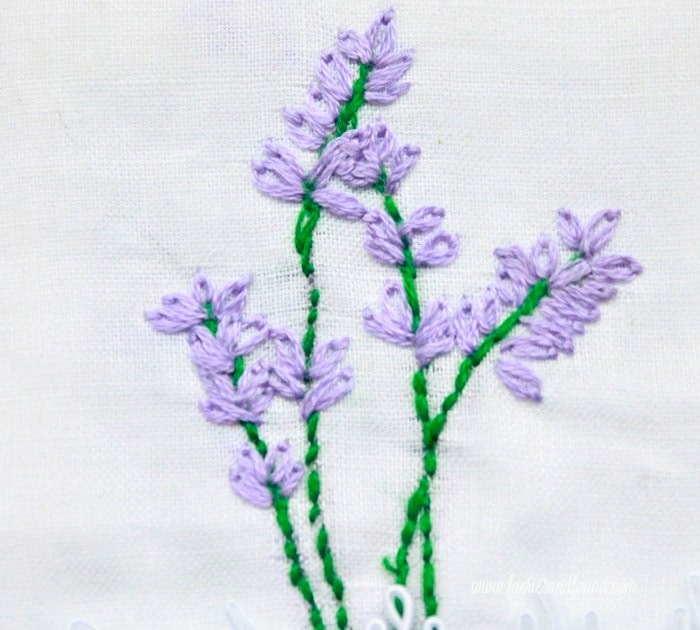 Finished lavender embroidery showing four sprigs stitched on fabric.
