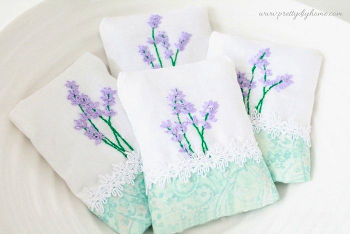 Four lavender sachets arranged in a white Emile Henry bowl.