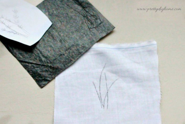 Layering fabric carbon paper and pattern to transfer a lavender embroidery design