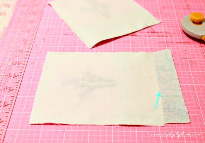 Trimming excess blue fabric from the bottom of a lavender sachet.