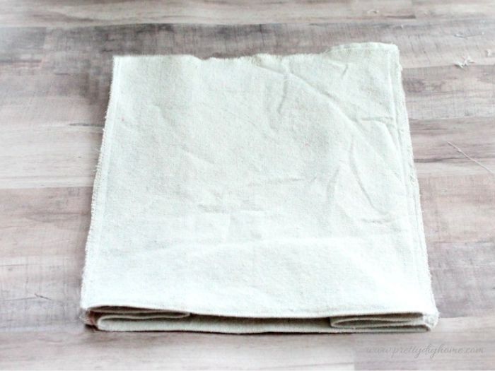 A sewn fabric basket liner is ready to be placed inside the basket before the top edge is folded over and pressed.