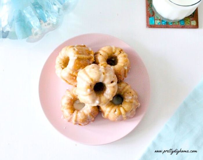 The top view of a tray of homemade baked pumpkin donuts.  There are six donuts in a stack.