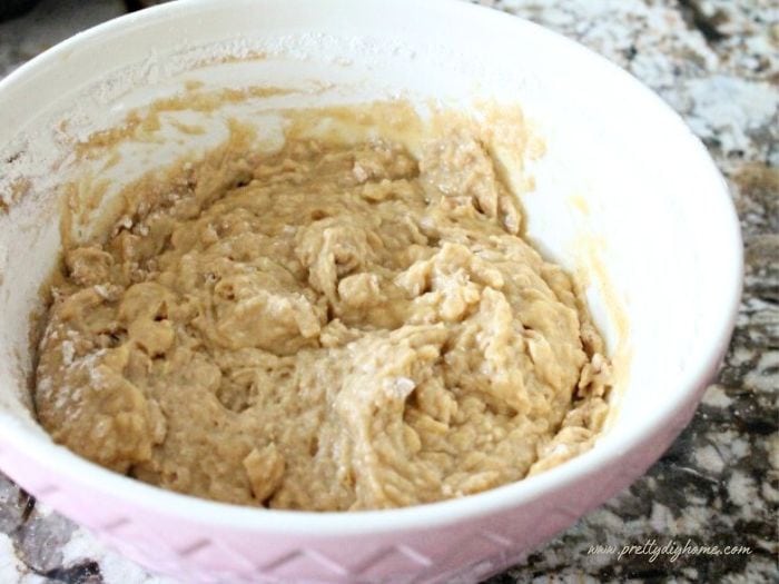 A large mixing bowl filled with freshly mixed pumpkin donut batter.