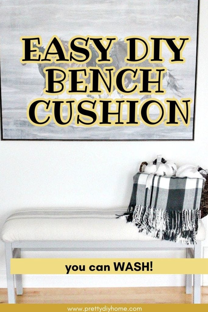 A beautiful white bench with a new DIY cushion top. The bench has a basket sitting on top and an imae of horses hanging on the walk behind it. The overlay text says Easy DIY Bench Cushion You can Wash.