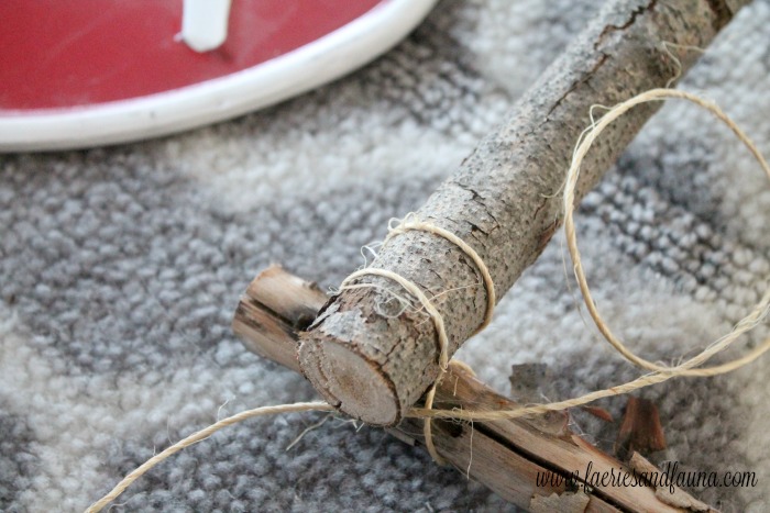 Tying knots to hold together branches on a DIY white birch wreath.