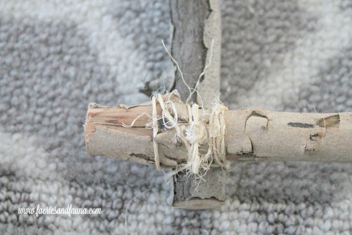 Binding the corners of a white birch DIY twig wreath for Christmas