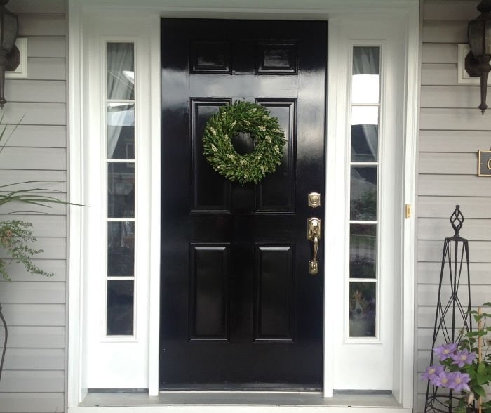 A shiny black door makeover with bright white trim.