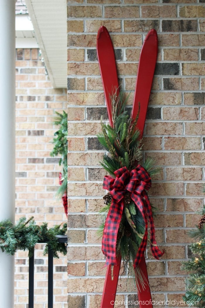 Decorating a Christmas front porch using thrift store skis,  An easy way to use vintage Christmas outside decor  on the front porch.