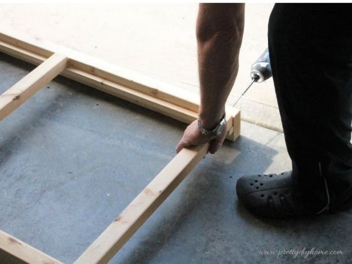 Installing cross supports between side rails on a DIY dog ramp frame.