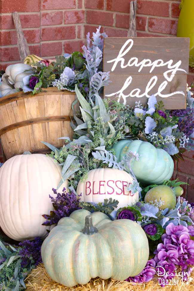 Fall porch with an colourful collection of green, purple, and white pumpkins.