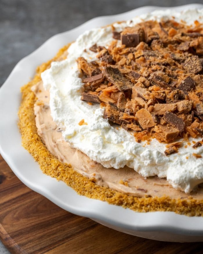 A thick cream a butterfinger covered pie with golden crumb crust.