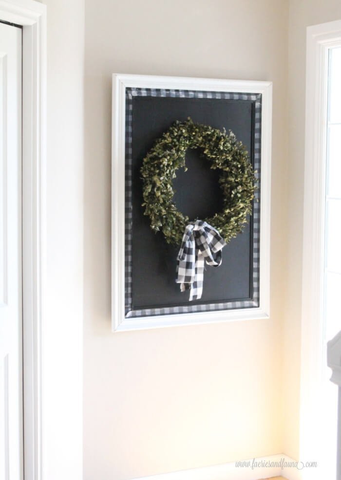 a large diy chalkboard with buffalo check trim, with a simple wreath.