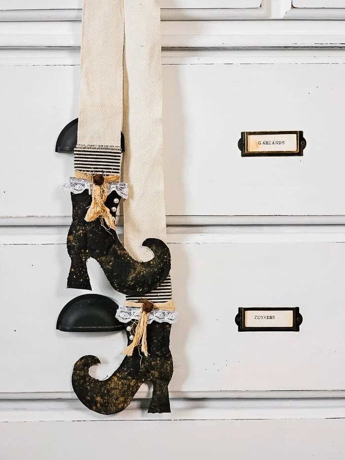 Very stylish black witch boots, hanging from a long cotton ribbon for elegant and simple Halloween decor.  The boots are made using paper bags, but they look almost like leather.