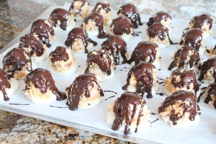 Chocolate being drizzled over caramel coconut shortbread cookies for Christmas.