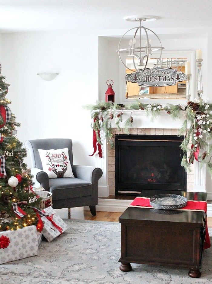 Adding ribbon to a Christmas fireplace mantel.