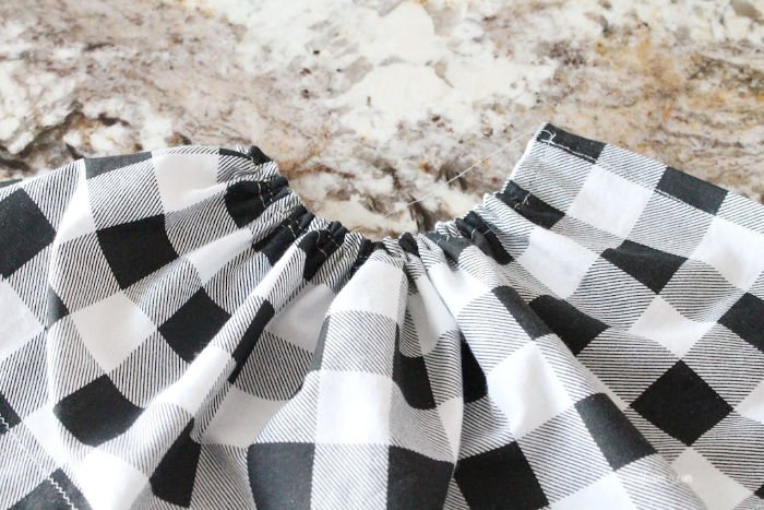Gathering buffalo check fabric for making an apron to attach to a DIY Easter bunny craft.