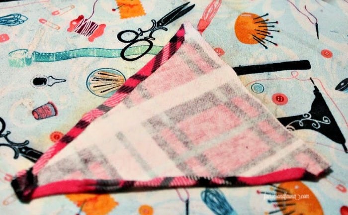 Folding over the edges of a fabric pennant for toys.