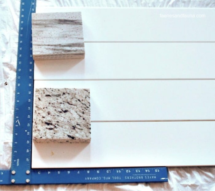 Using a square to line up shiplap for a farmhouse backdrop for decorating.