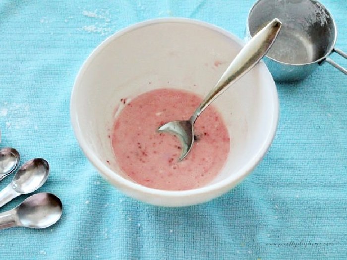 A small bowl filled with lemon strawberry glaze.  